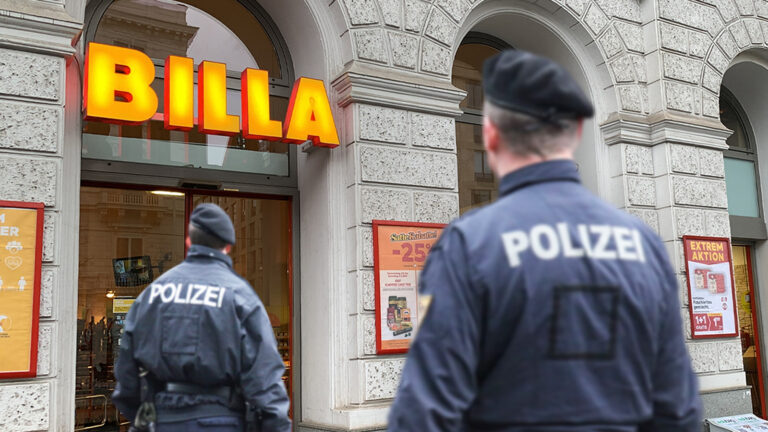 Das Bild zeigt zwei Polizisten vor einem Billa.