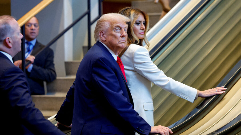 Das Bild zeigt Trump auf der stecken gebliebenen Rolltreppe.