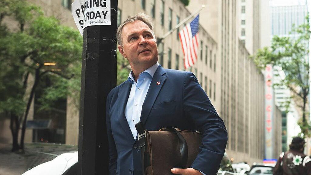 Das Bild zeigt Andreas Babler in New York, im Hintergrund weht eine US-Flagge.