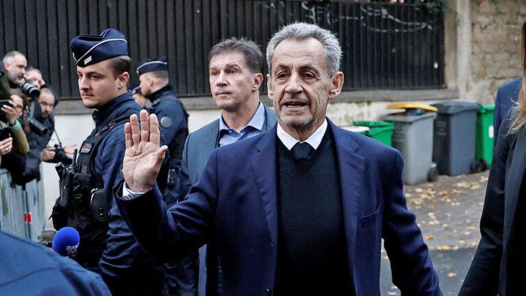Das Bild zeigt Sarkozy mit erhobener Hand. Es sieht so aus als würde er etwas schwören.