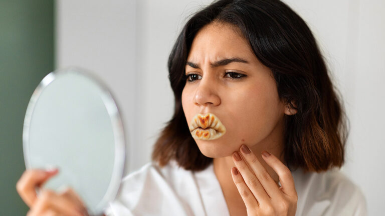 Das Bild zeigt eine Frau, die in den Spiegel sieht. Statt Lippen hat sie eine Mundförmige Gyoza im Gesicht.