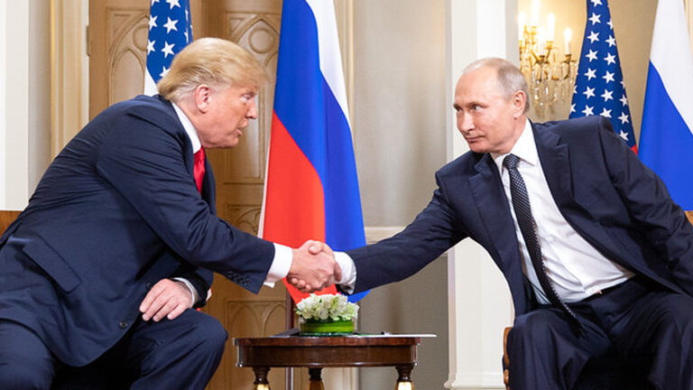 Das Bild zeigt Trump und Putin, wie sie sich die Hand geben.