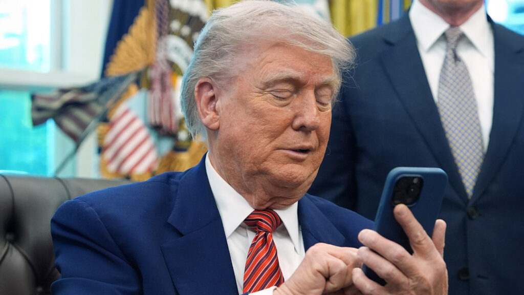 Das Bild zeigt Trump, wie er lüstern auf sein Handy starrt.