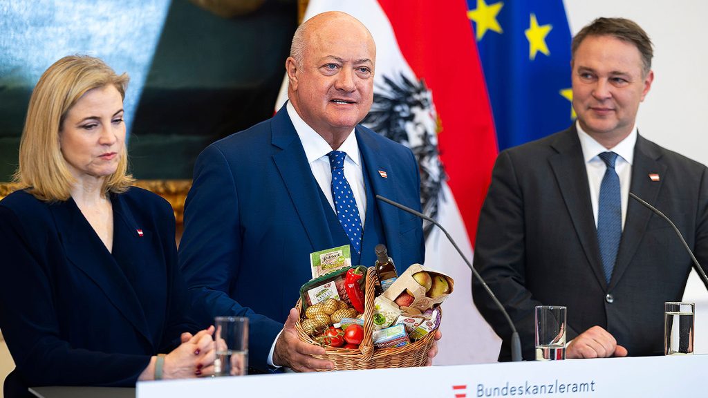 Das Bild zeigt Meinl-Reisinger, Stocker und Babler. Stocker hält einen Korb voller Lebensmittel.