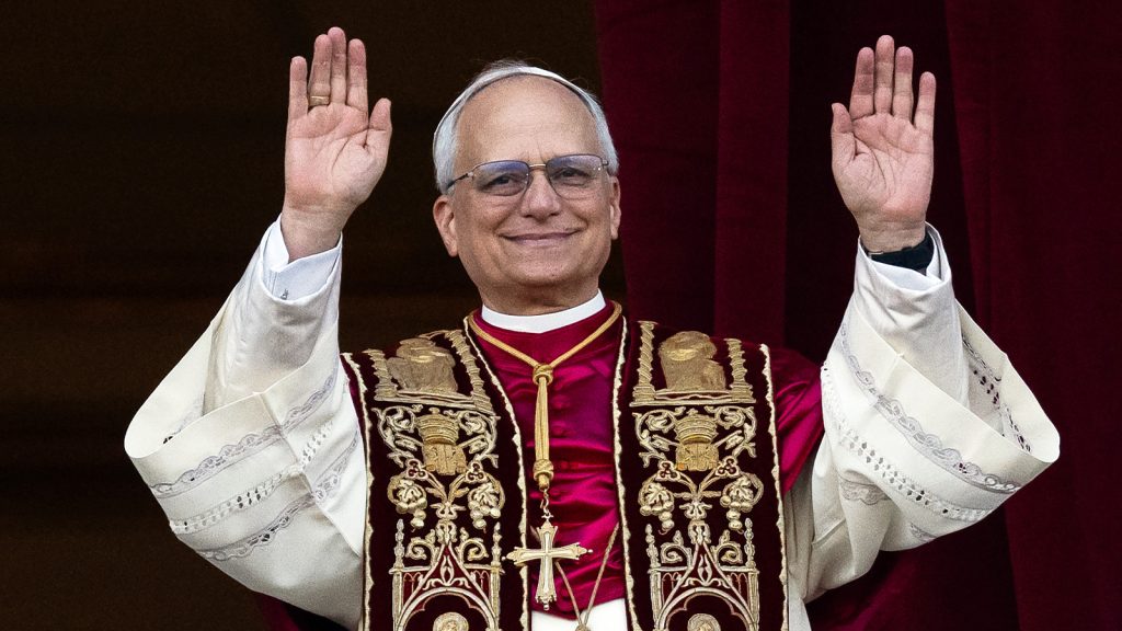 Das Bild zeigt Papst Leo mit erhobenen Händen.