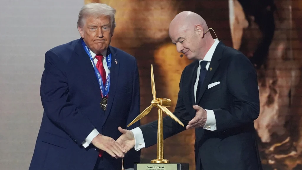 Das Bild zeigt Infantino, wie er Trump ein goldenes Windrad überreicht.