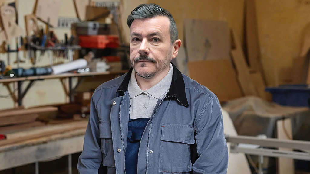 Das Bild zeigt Rene Benko in einer Tischlerei.