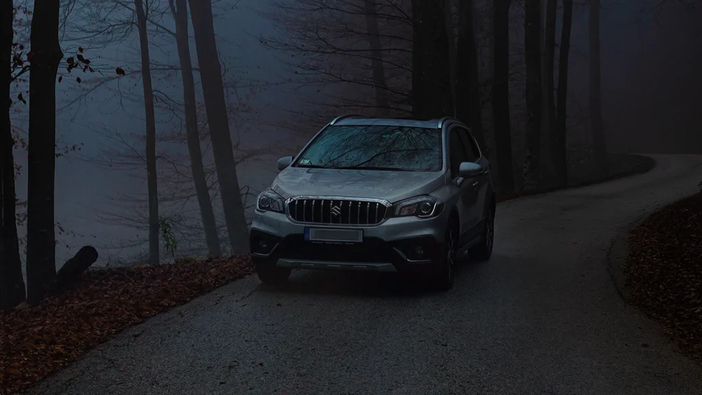 Das Bild zeigt ein Auto ohne Licht auf einer düsteren Straße.