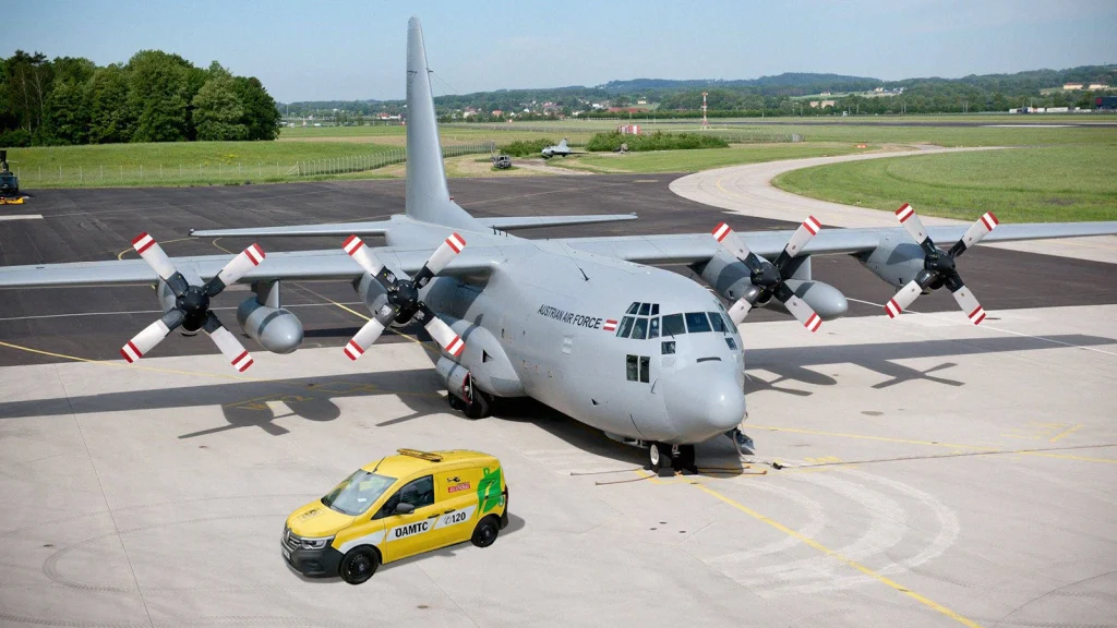 Das Bild zeigt ein Hercules Flugzeug und ein ÖAMTC Auto auf einem Flugplatz.