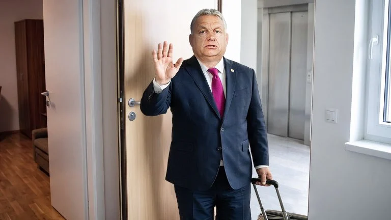 Das Bild zeigt Viktor Orban beim Betreten einer Wohnung mit Koffer.