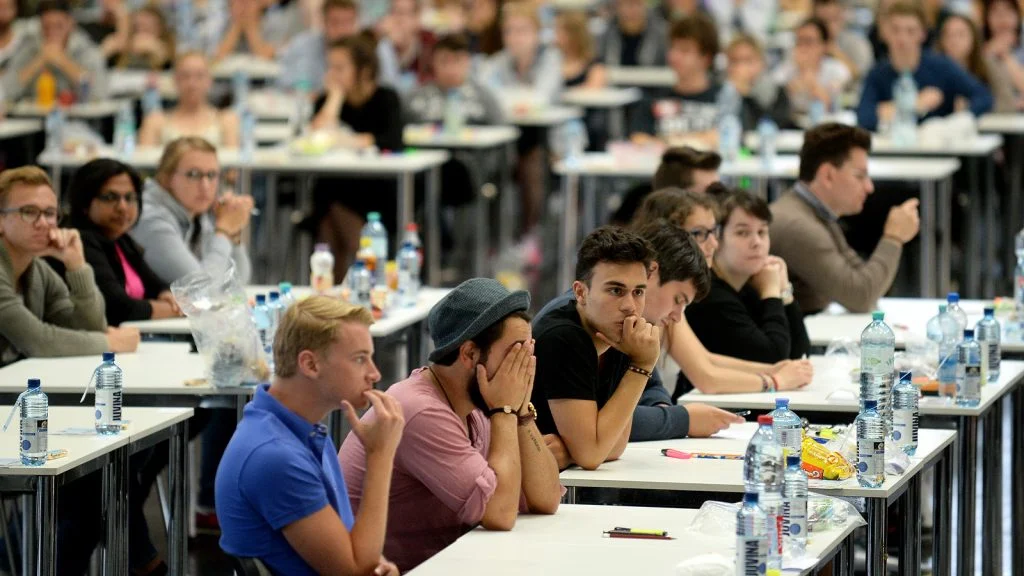 Das Bild zeigt verzweifelt aussehende Student:innen.