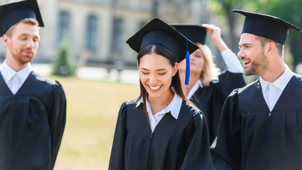 Das Bild zeigt Studenten bei einer Abschlussfeier.