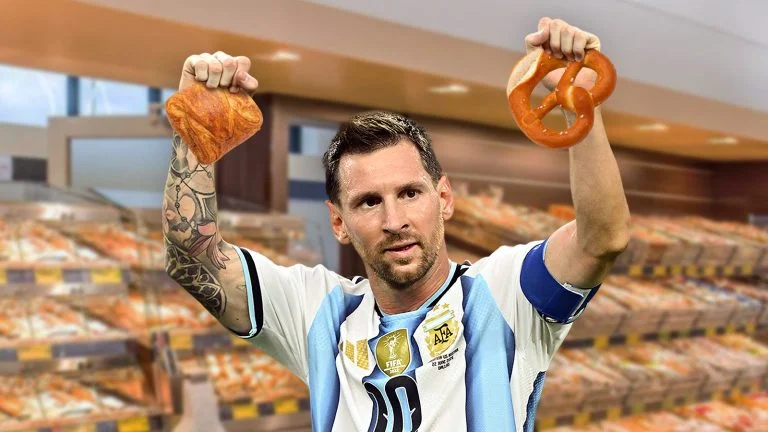 Das Bild zeigt Messi vor der Hofer Backbox. In einer Hand hält er eine Topfengolatsche und in der anderen eine Laugenbrezn.