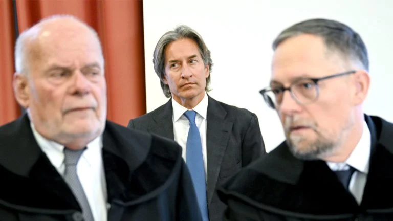 Das Bild zeigt Grassers Anwälte, im Hintergrund sieht man Grasser.