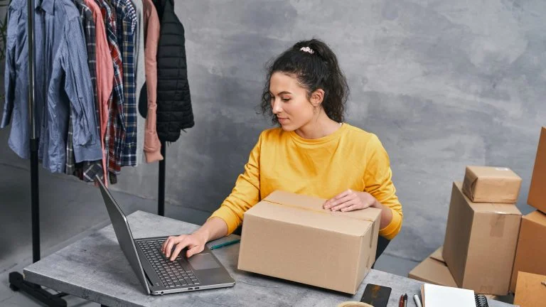 Frau am Laptop mit Paket