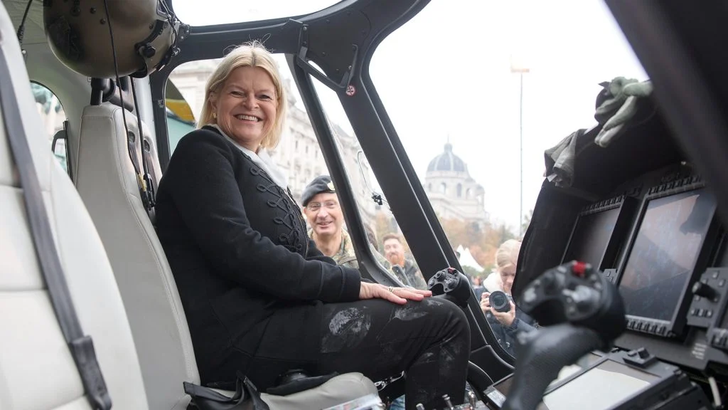 Das Bild zeigt Tanner in einem Heli mit einem großen Grinsen auf den Lippen.