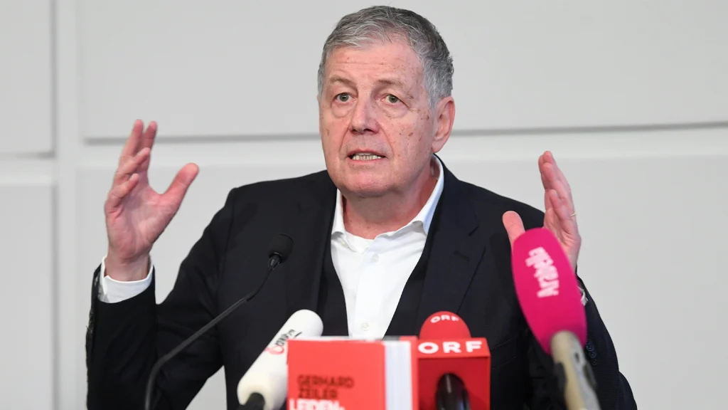 Das Bild zeigt Gerhard Zeiler mit verwirrtem Blick bei einer Pressekonferenz.