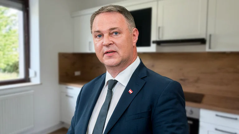 Das Bild zeigt Andreas Babler mit verwirrtem Blick in einer WG-Küche.